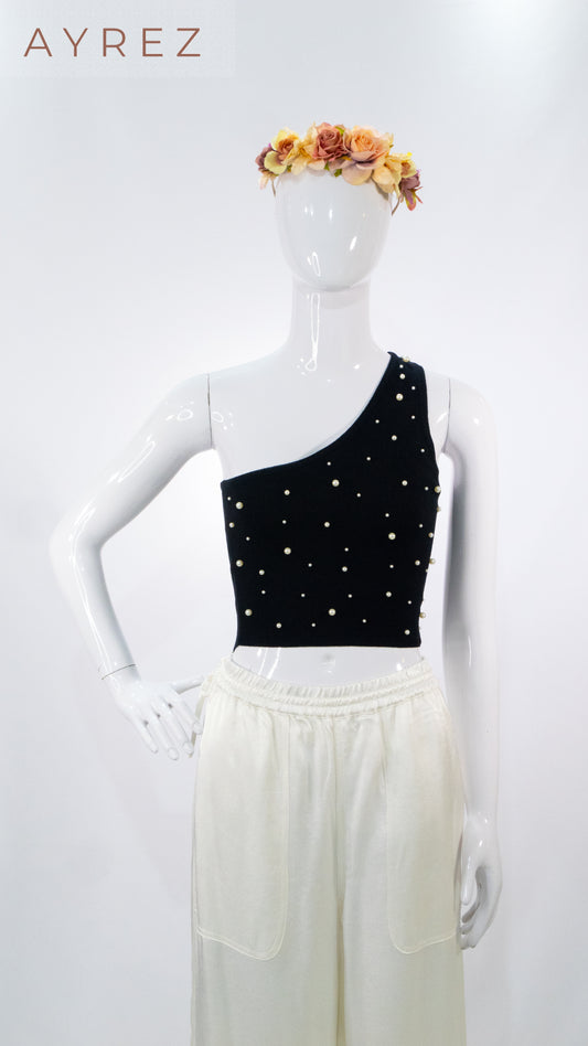 Top negro asimétrico con aplicaciones y pantalón de lino blanco